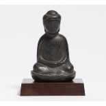 A RELIEF FIGURE OF A BUDDHA IN MEDITATION ON LOTUS BASE. Japan. 18th-19th c. Bronze with dark patina