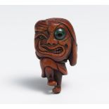 NETSUKE OF A GHOST WITH A LARGE HEAD (ÔKUBI BAKEMONO). Japan. 19th c. Dark wood, carved, eyes inlaid