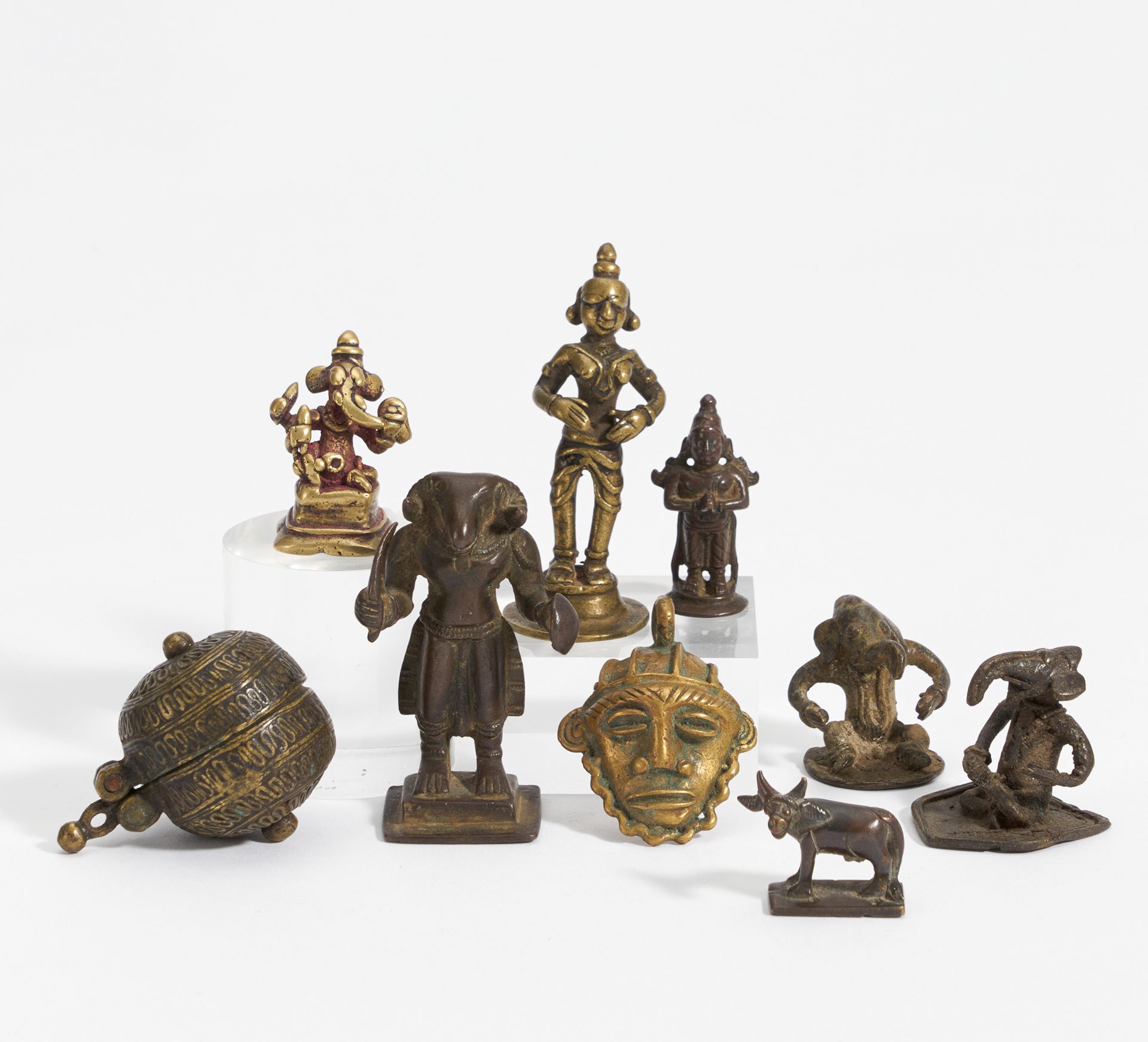 NINE SMALL FIGURES, MASK AND BOX. India. 18th-20th c. Bronze, partly with dark patina and residue of