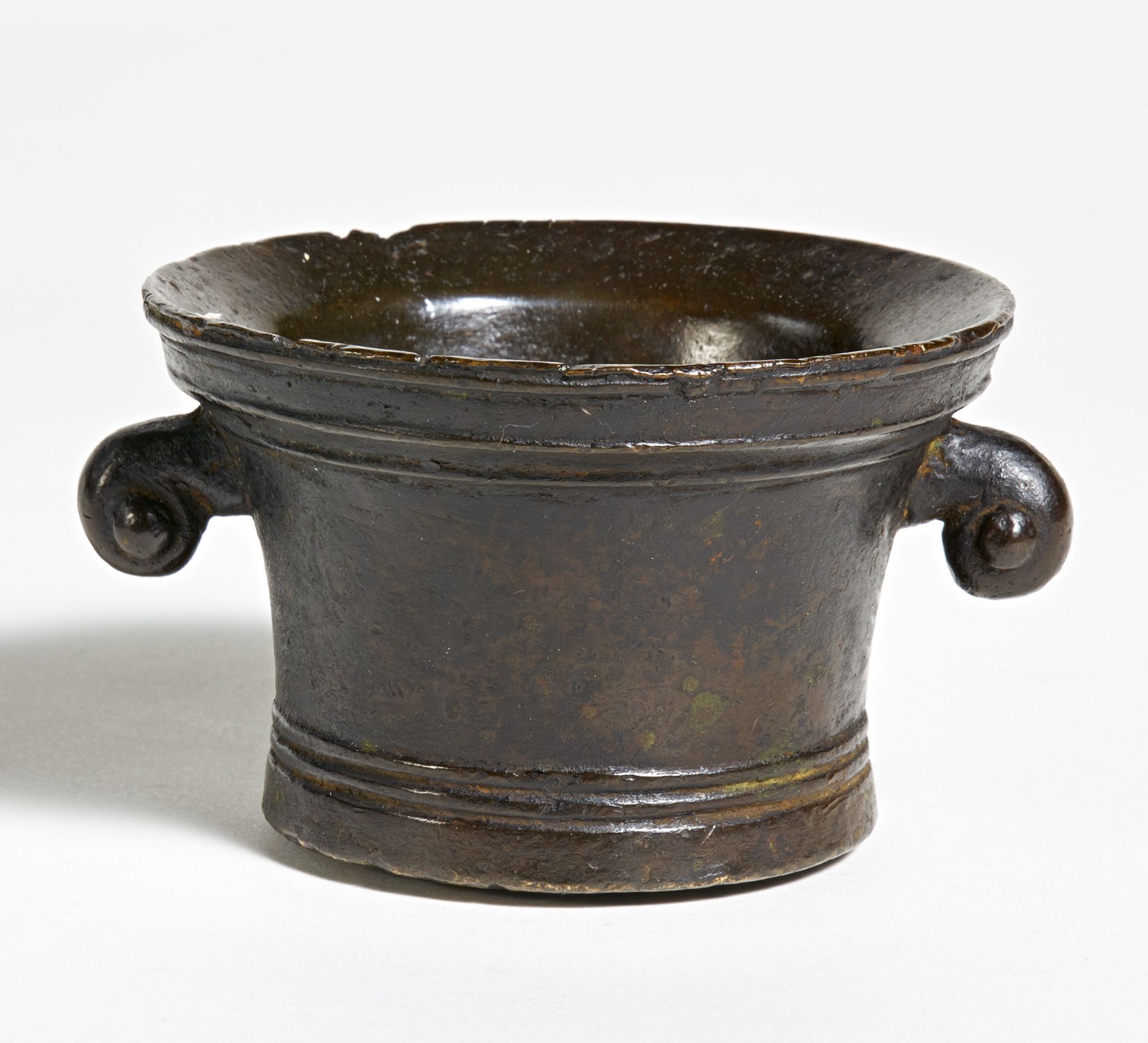 KLEINER MÖRSER MIT VOLUTENHENKELN. Bronze. H.7,5cm, ø11,5cm. Zustand B/C. Provenienz:Sammlung