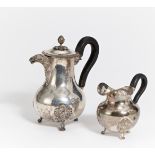 KAFFEEKANNE MIT RELIEFZIER UND MILCHKÄNNCHEN. Belgien. Silber. Je Holzhenkel. Ca. 692g. H.20/13cm.