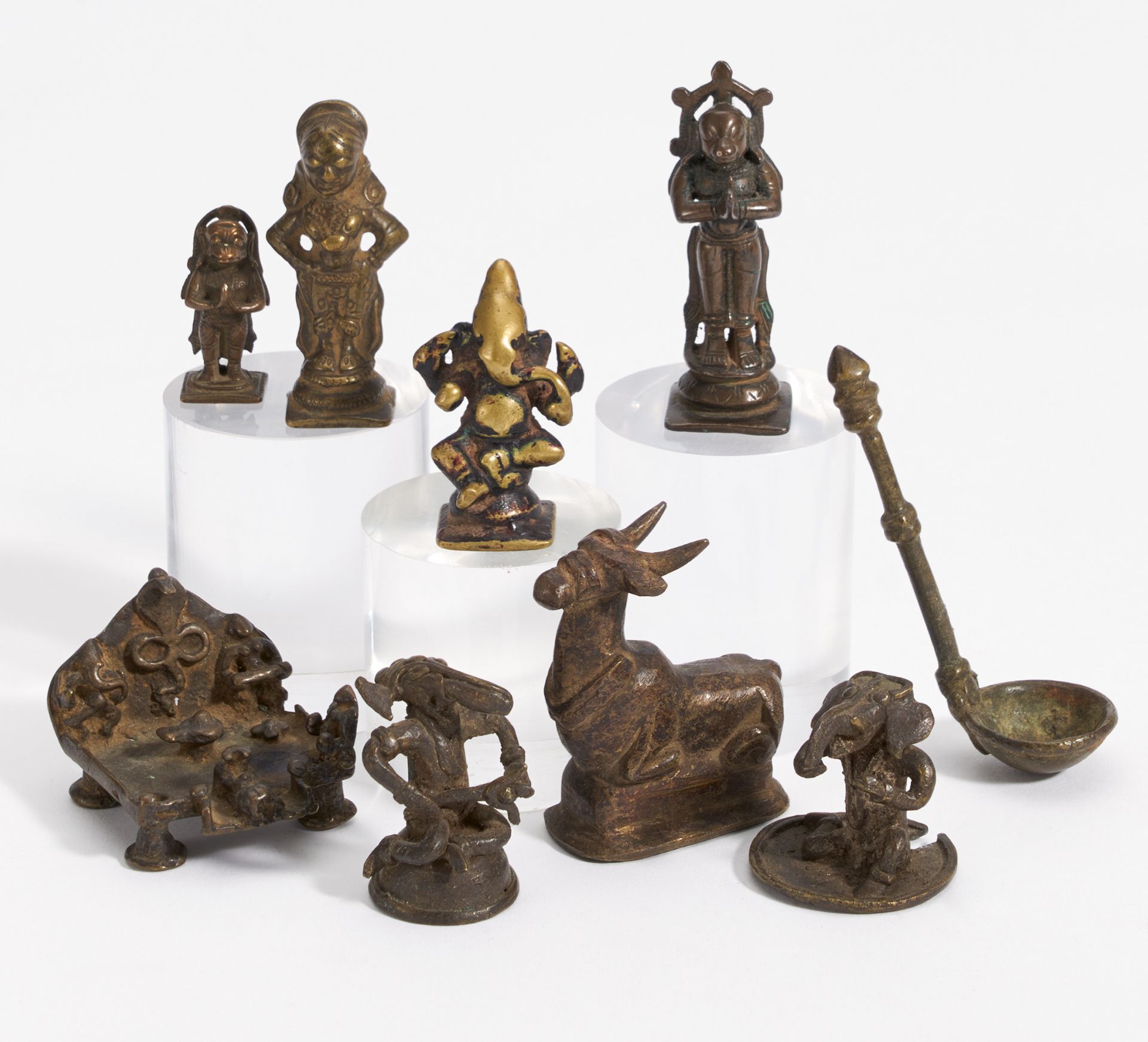 EIGHT FIGURES OF GODS AND A SMALL SPOON. India. 18th-20th c. Bronze with dark patina and residue