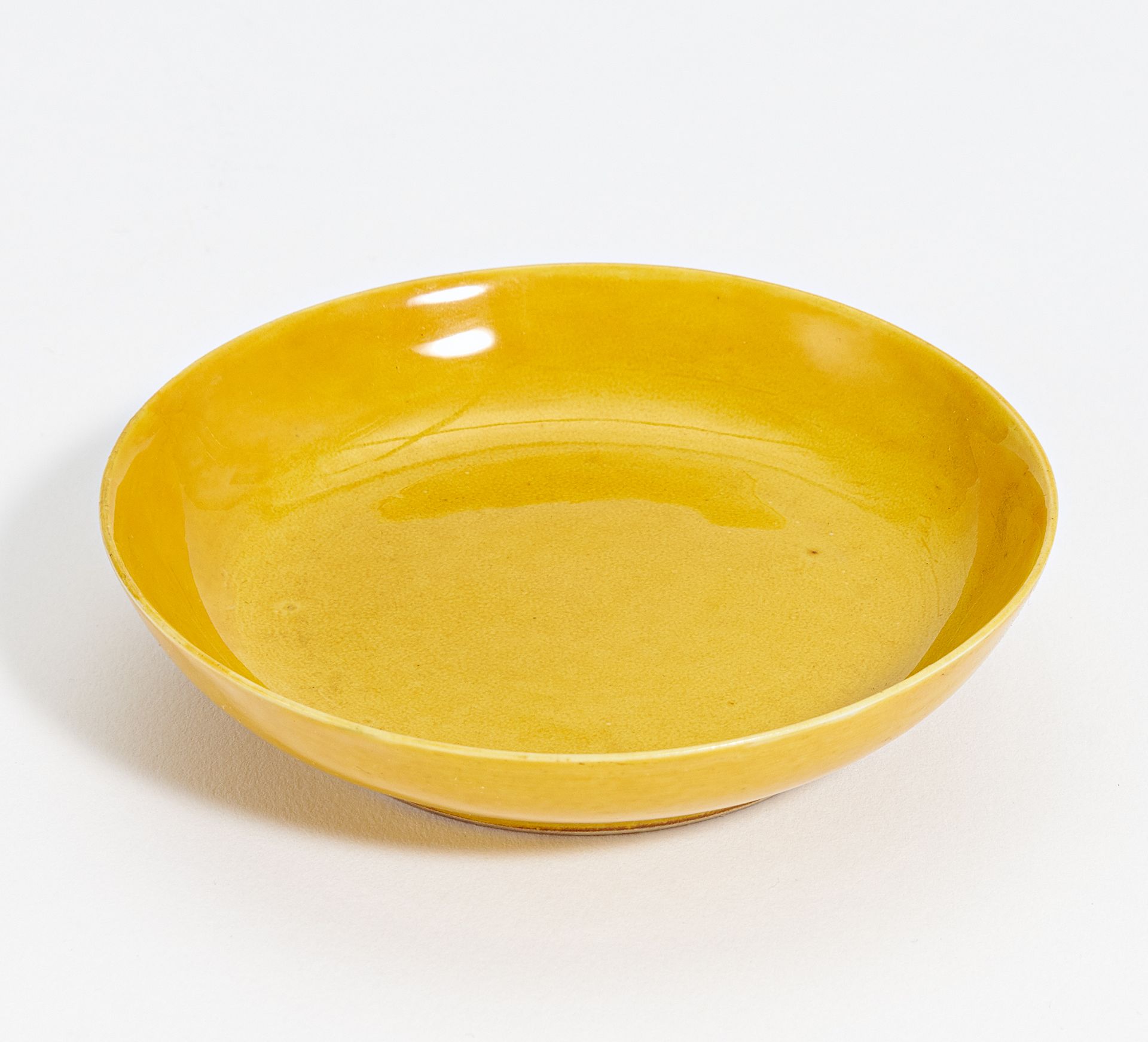 SMALL YELLOW-GLAZED DISH. China. Qing Dynasty. Tongzhi period (1861-1875). Porcelain, inside and