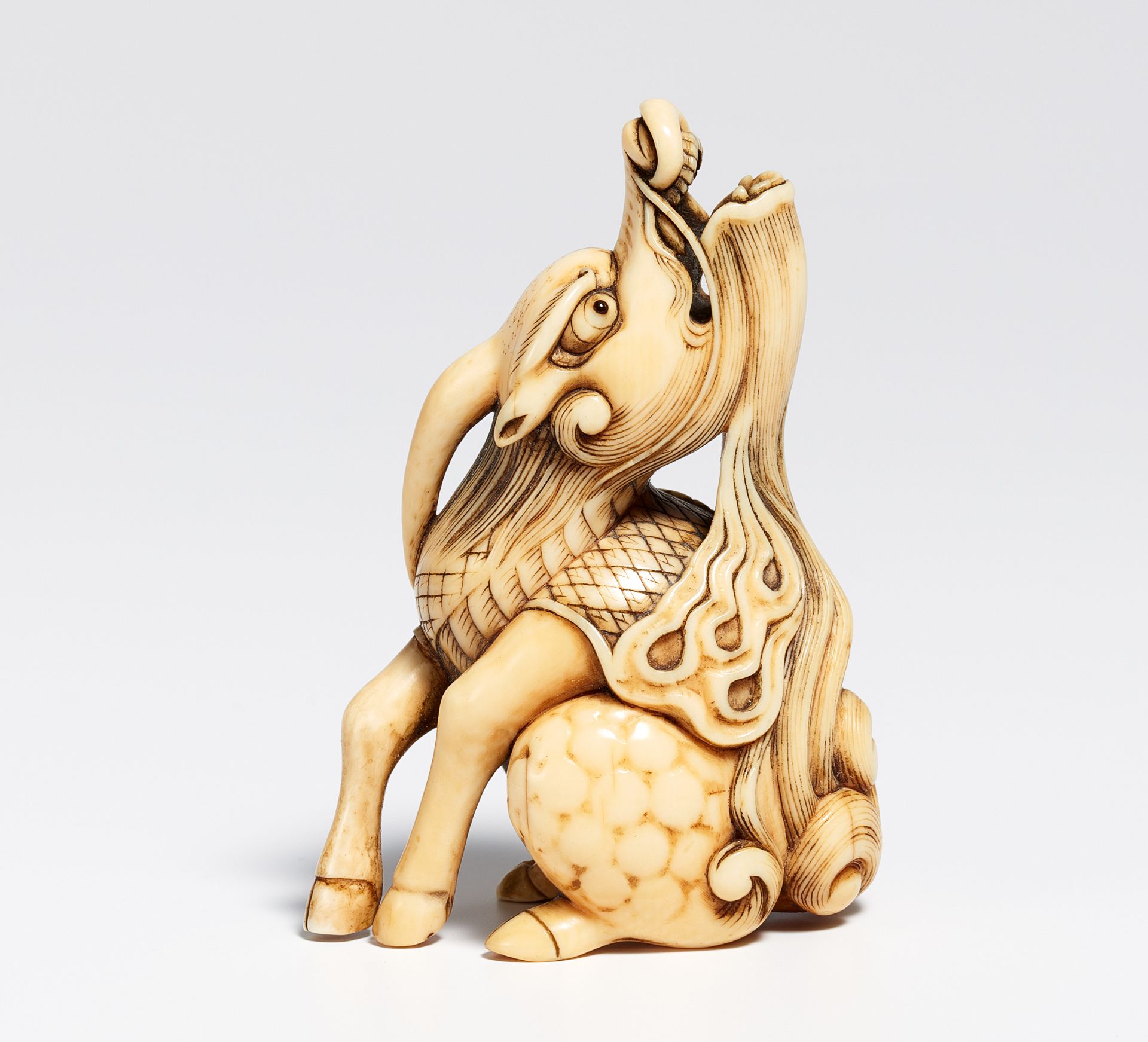 NETSUKE OF A SITTING KIRIN. Japan. 19th c. Ivory, carved and engraved, partly stained in black. H. - Bild 2 aus 2