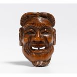 NETSUKE: MASK OF AN OLD MAN (KOJO). Japan. 19th c. Wood, carved. H.4.5cm. Sign.: 89 years old