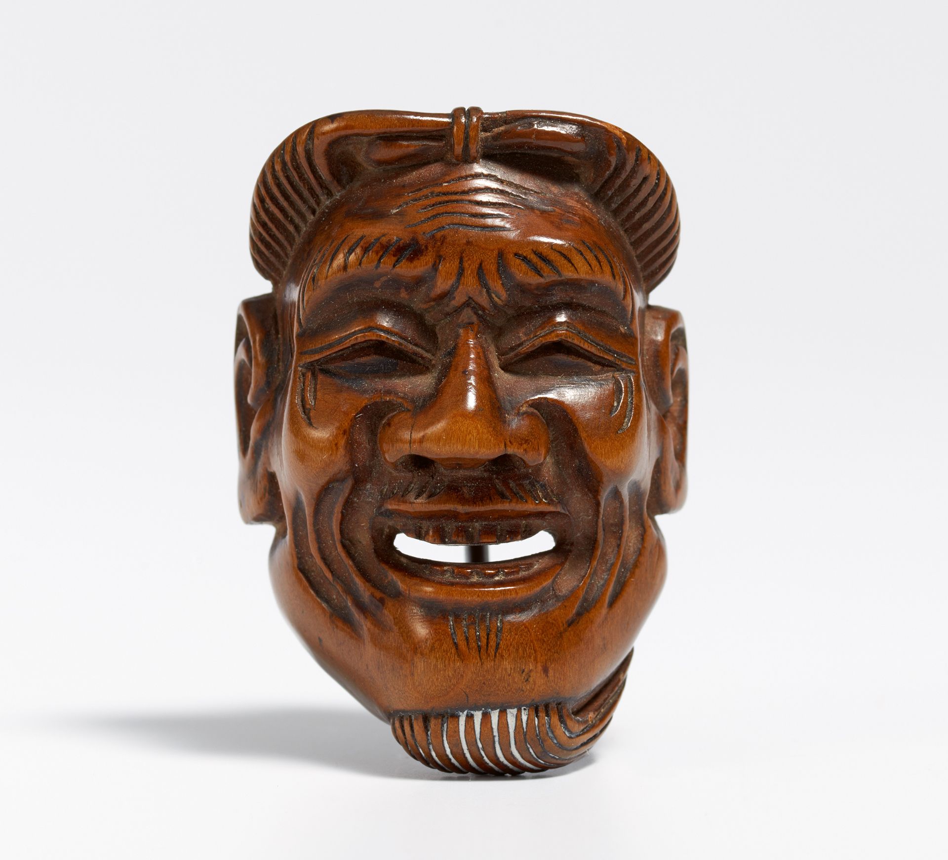 NETSUKE: MASK OF AN OLD MAN (KOJO). Japan. 19th c. Wood, carved. H.4.5cm. Sign.: 89 years old