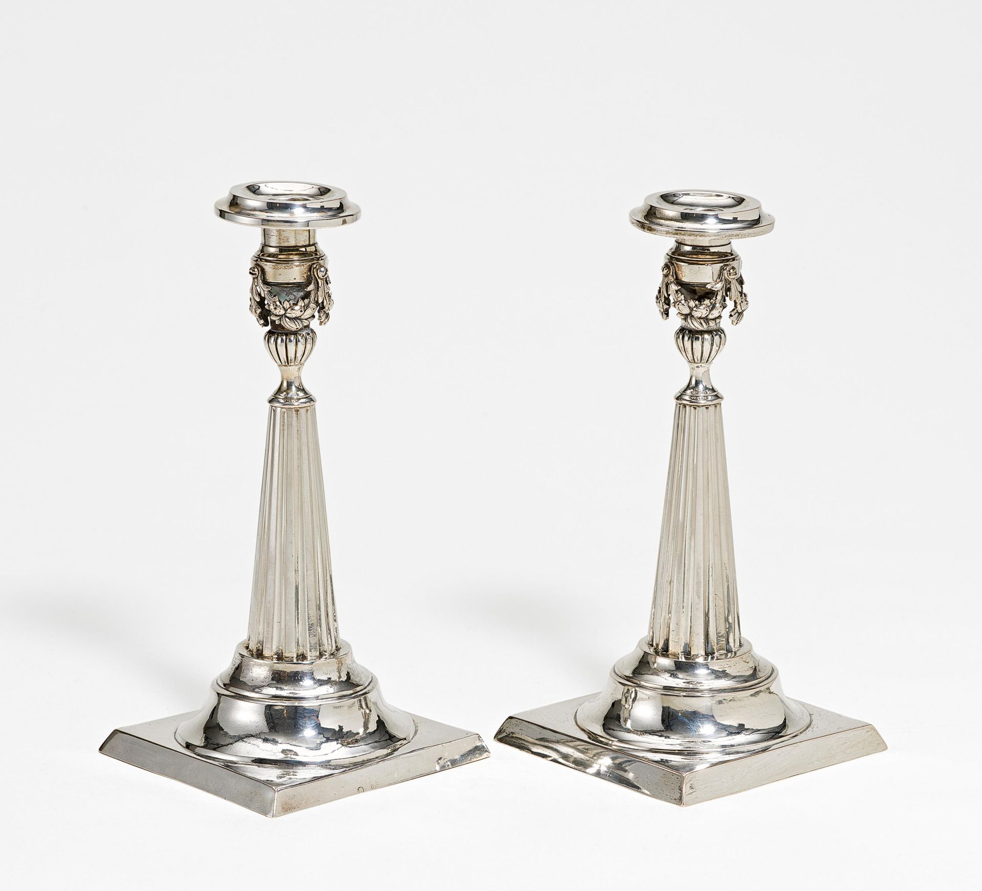 Pair of silver candlesticks with fluted shaft and festoons