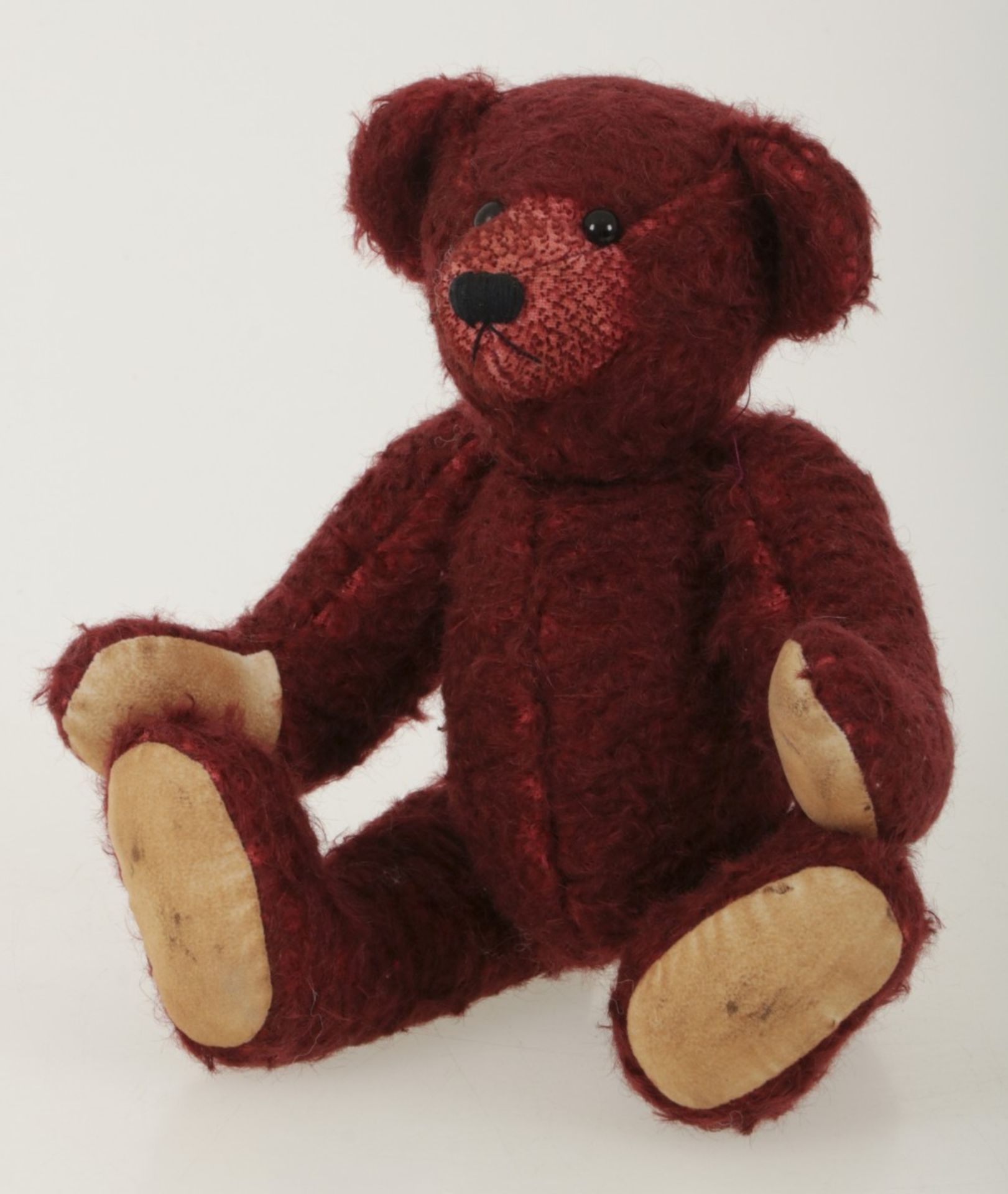 A burgundy coloured so-called 'Teddy' bear. Possibly Steiff.