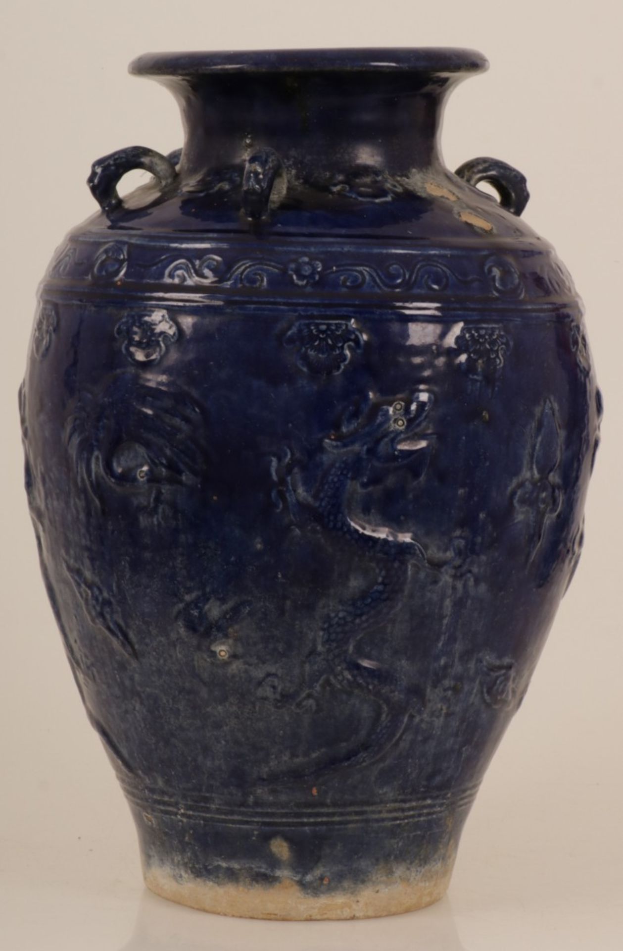 An earthenware blue glazed storage jar with dragon decoration. China, 20th century.