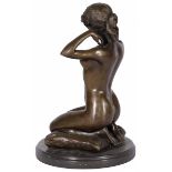A bronze sculpture of a crouching gypsy on a pillow, France(?), 20th century.