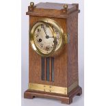 An European 'Arts & Crafts' style oak mantle clock with brass fittings.