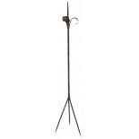 A wrought iron pricket candlestick with lily shaped leafs on top.