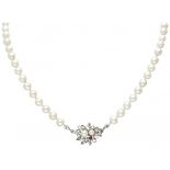 Single strand pearl necklace with a 14K. white gold closure set with pearl and ruby.