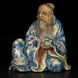 A sitting porcelain philosopher with a peach in his hand, China, 19/20th century.