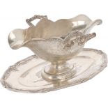 Sauce boat with silver saucer.