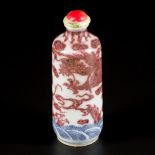 A porcelain iron-red snuff bottle decorated with dragons, China, 19th century.