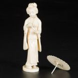 An ivory sculpture in the shape of a dame with an umbrella. Japan, late Meji period.