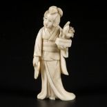 An ivory okimono of a Japanese lady wih a bonsai tree. Japan, late Meiji period.