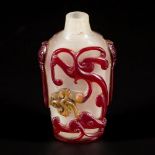 A glass snuff bottle decorated with red dragons, China, circa 1800.