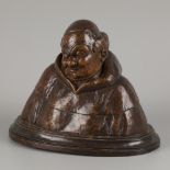 A wooden bust of a happy monk.