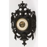 A carved and blackened wooden Louis XVI-style barometer, France, late 19th century.