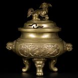 A bronze koro decorated with flowers and animals, on the lid and the sides a foo dog and the legs dr