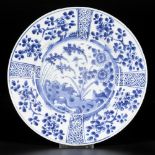 A porcelain plate with 4-compartment outer rim decor, in the centre floral decorations with bird, Ch