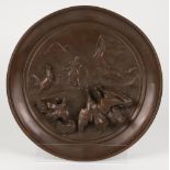 A bronze commemorative dish with high relief of a peasantwoman feeding poultry.
