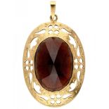 Vintage pendant with garnet in an openwork engraved 14K. yellow gold frame.