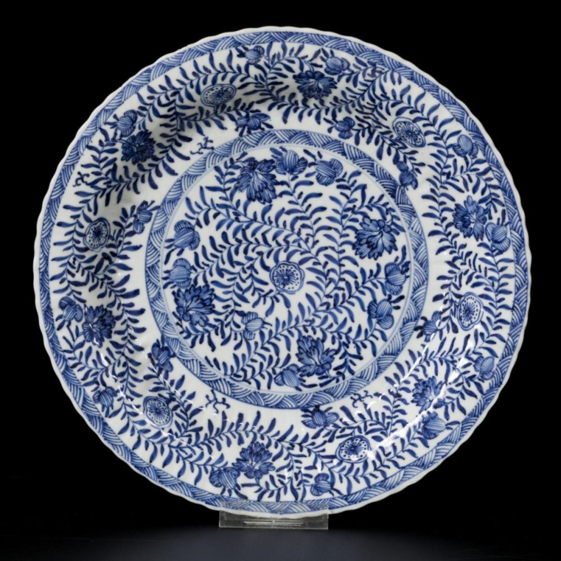 A porcelain ribbed charger with floral decoration, China, Kangxi.