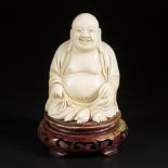 An ivory-sculpted Buddha on a wooden base. China, late 19th century.