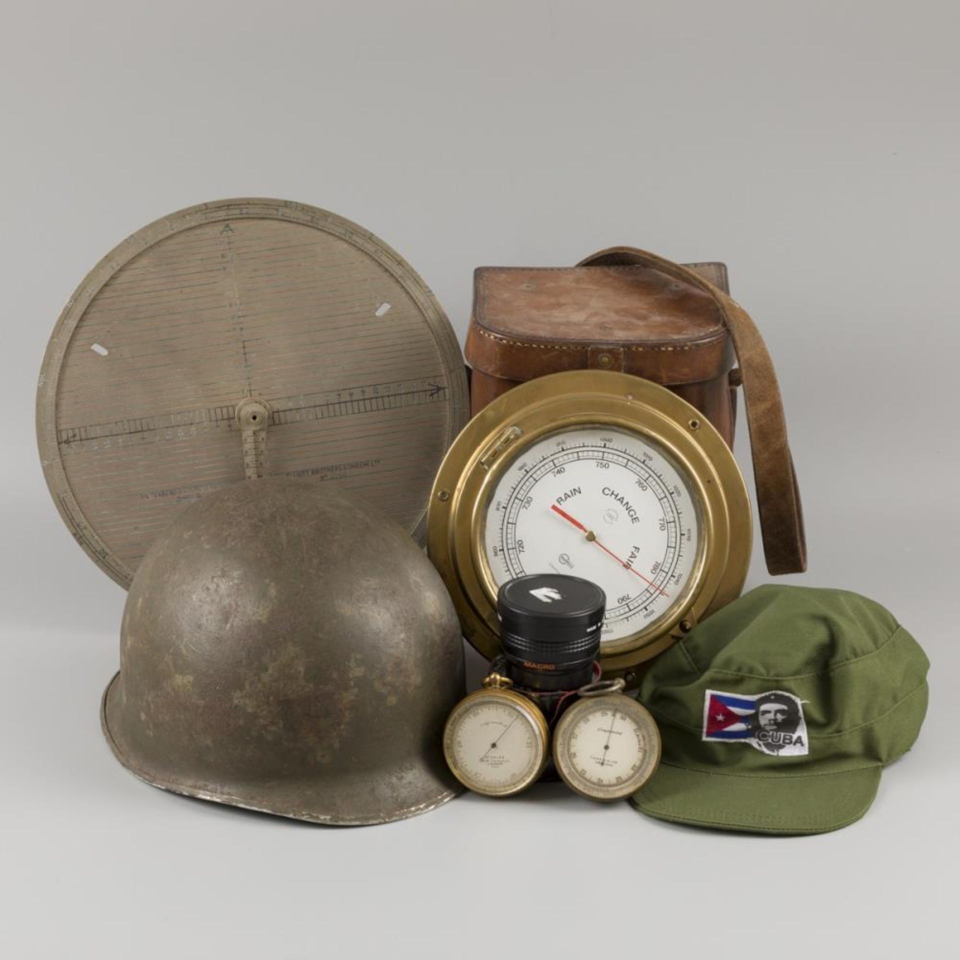 A lot comprising various items, a.w. an American helmet and Cuban cap, together with (2x) hand barom