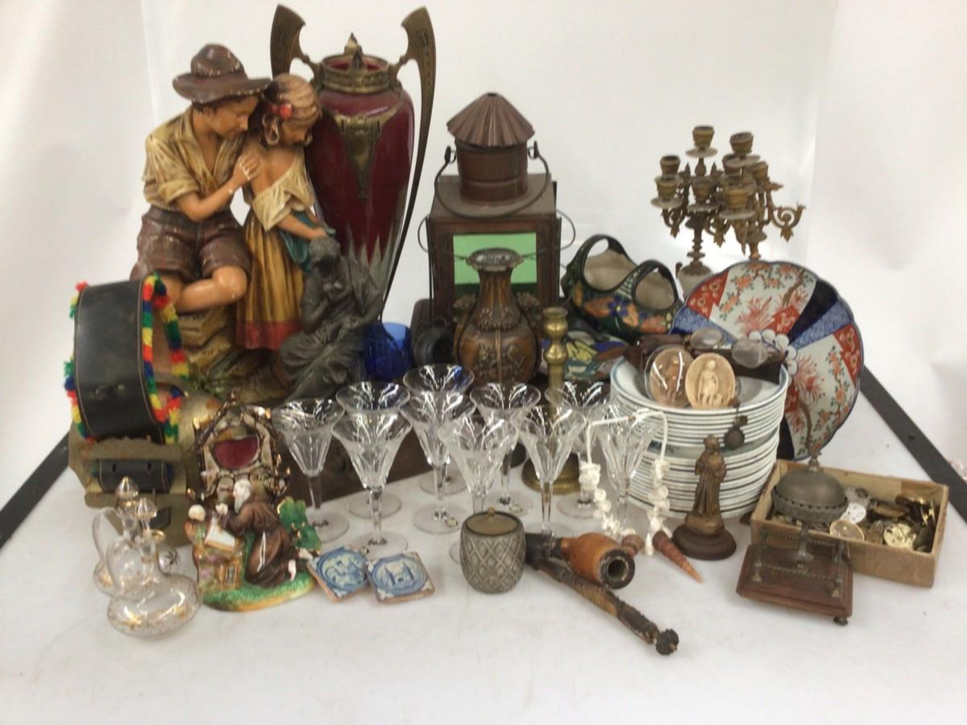 A lot with a cowbell, a ship's lantern, glass saucers, carafes, a few "Delft" tiles and glassware.