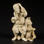 An ivory okimono depciting an old man and a wolf, Japan, Meiji period, ca. 1910.