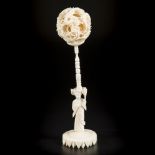 An ivory puzzle ball on ivory stand. China, circa 1920.