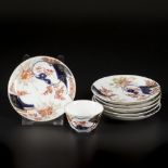 A lot of porcelain plates and a cup, all with Imari decoration. Japan, 18th century.