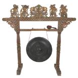 A large carved Indonesian gong with Wajang carvings.
