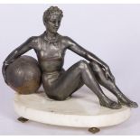 A ZAMAC statuette of a seated turning lady with large ball, France, mid. 20th century.