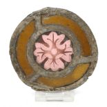 A roundel with a flower, pot-metal, early 14th century.