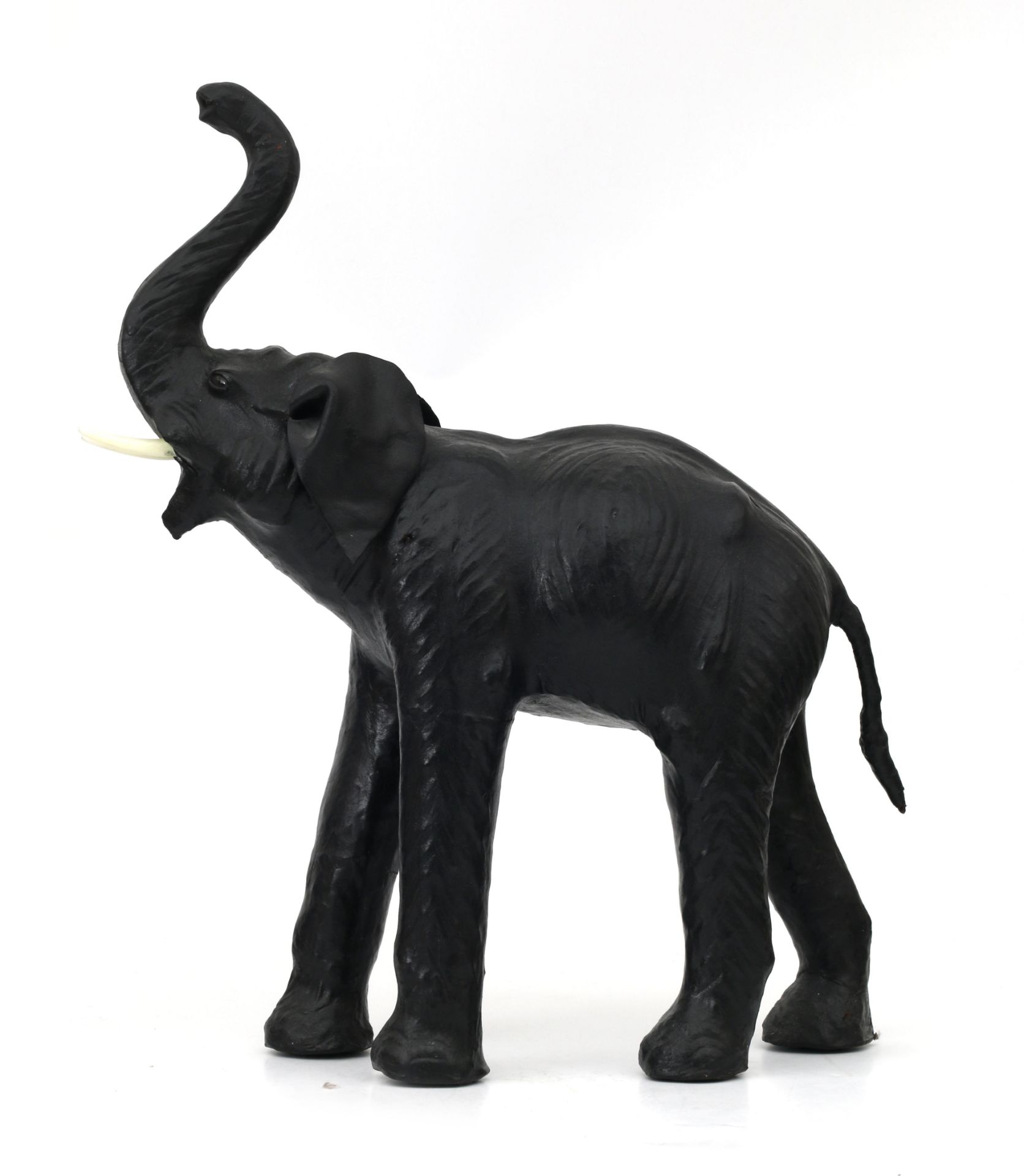 A black leather lined figure of an elephant with white plastic tusks. 75 x 65 x 23 cm. (hxwxd)