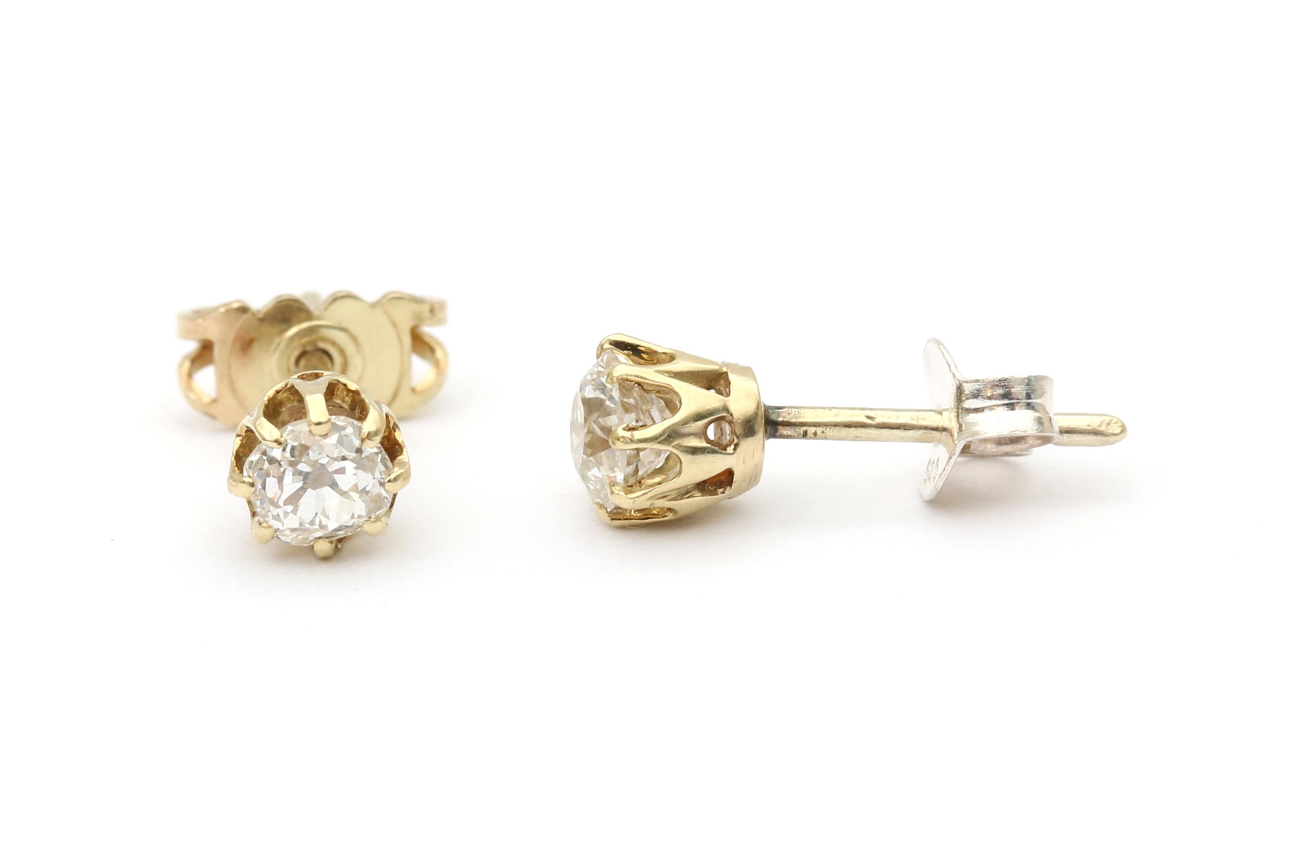 A pair of gold diamond solitair studs