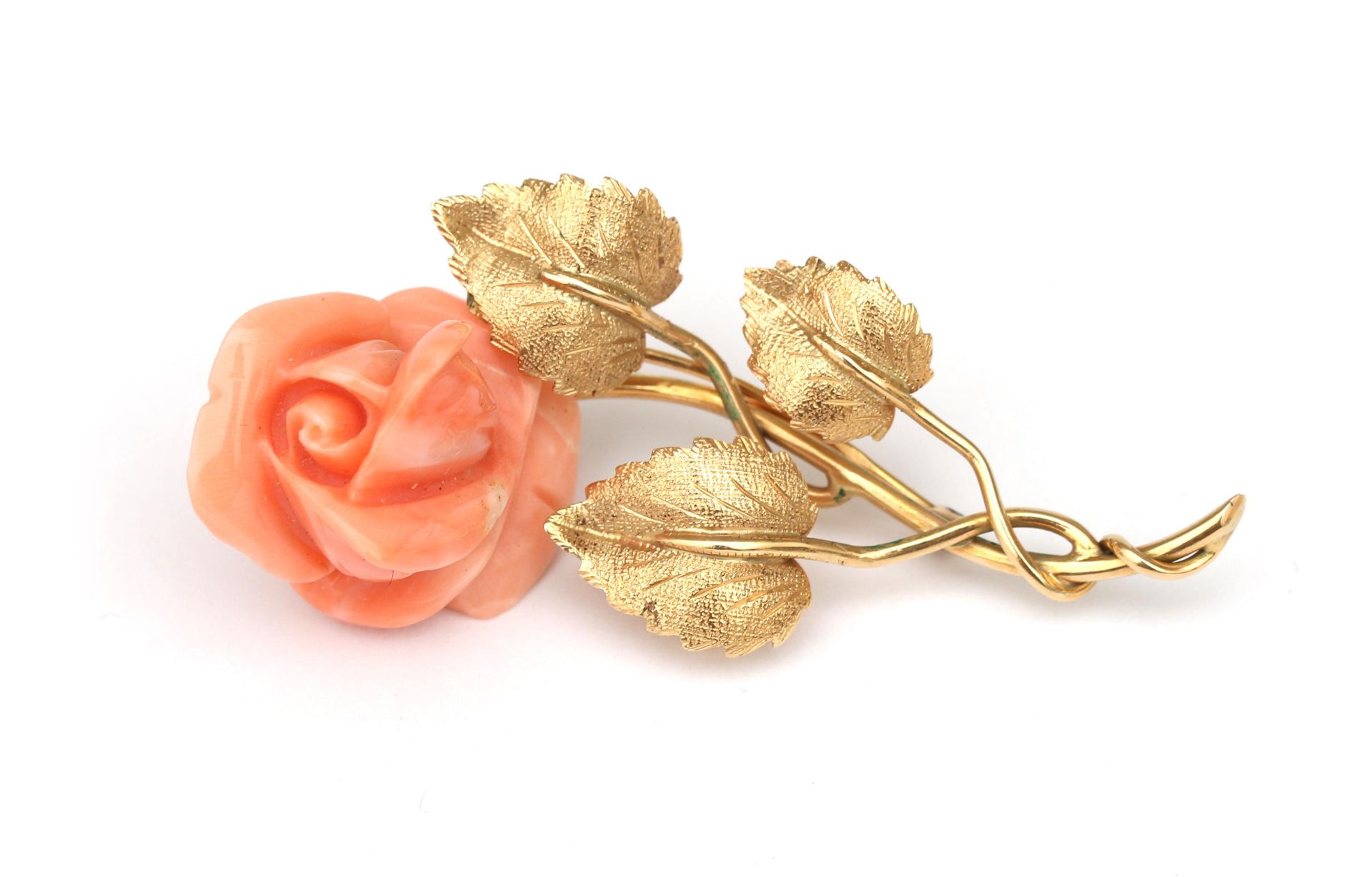 An 18 karat gold flower brooch with angelskin coral