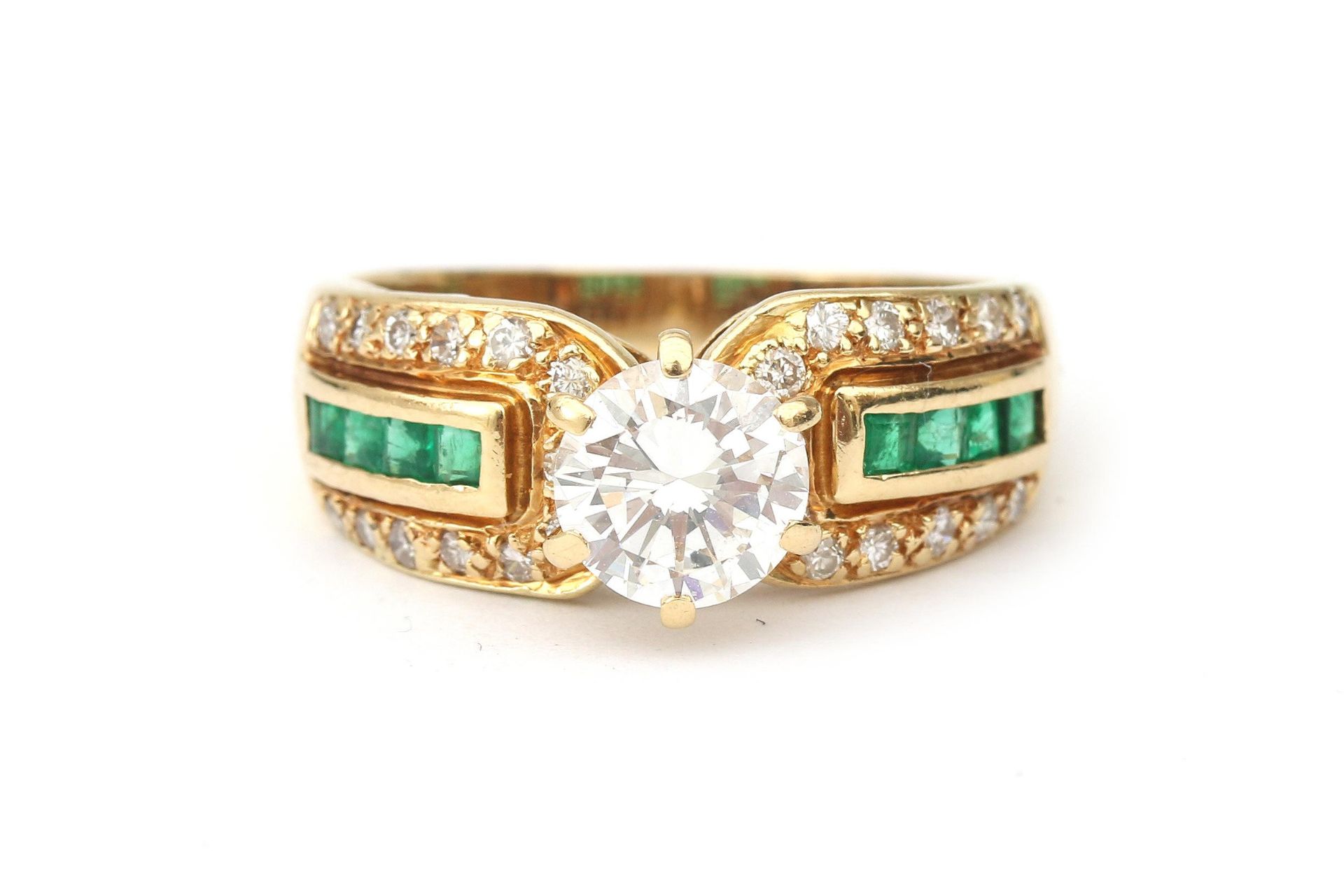 An 18 karat gold emerald and diamond solitaire ring, 1.07 ct.