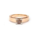 A 14 karat rose gold solitaire diamond ring