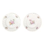 A pair of porcelain plates with gilded scalloped edge decorated with polychrome flowers, Tournai/The