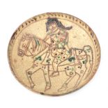 An earthenware Persian Kashan dish with sgrafitto decoration of a horse man, 11th/12th century.
