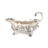 An 925 silver gravy boat on three feet with embossed- and engraved floral decoration, Robert Brown,