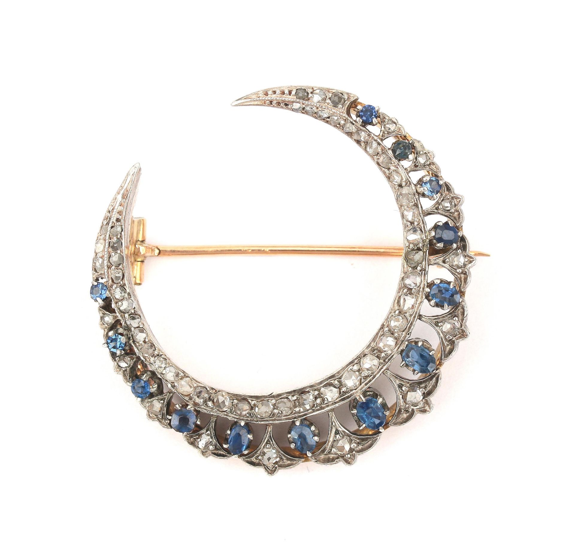 A 14 karat gold and silver sapphire and diamond crescent brooch