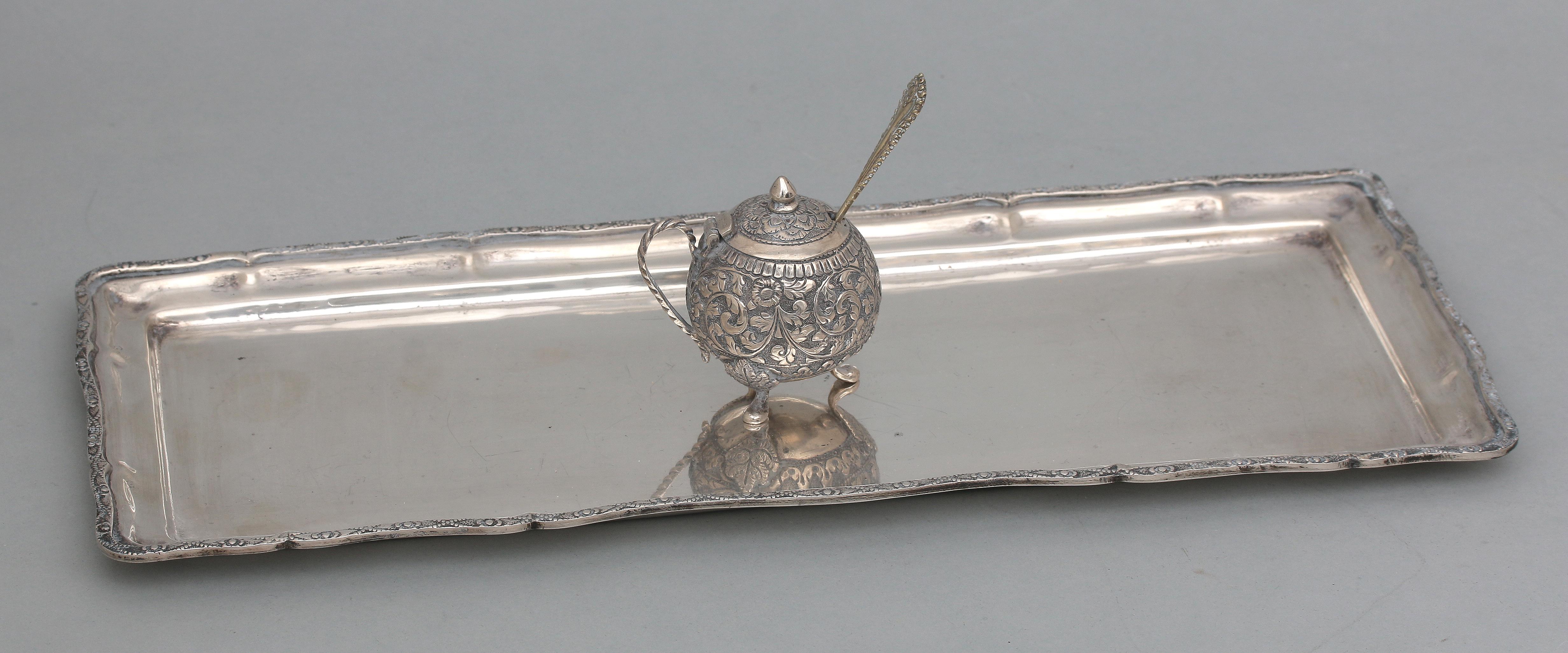 A olongated silver tray and mustard pot.