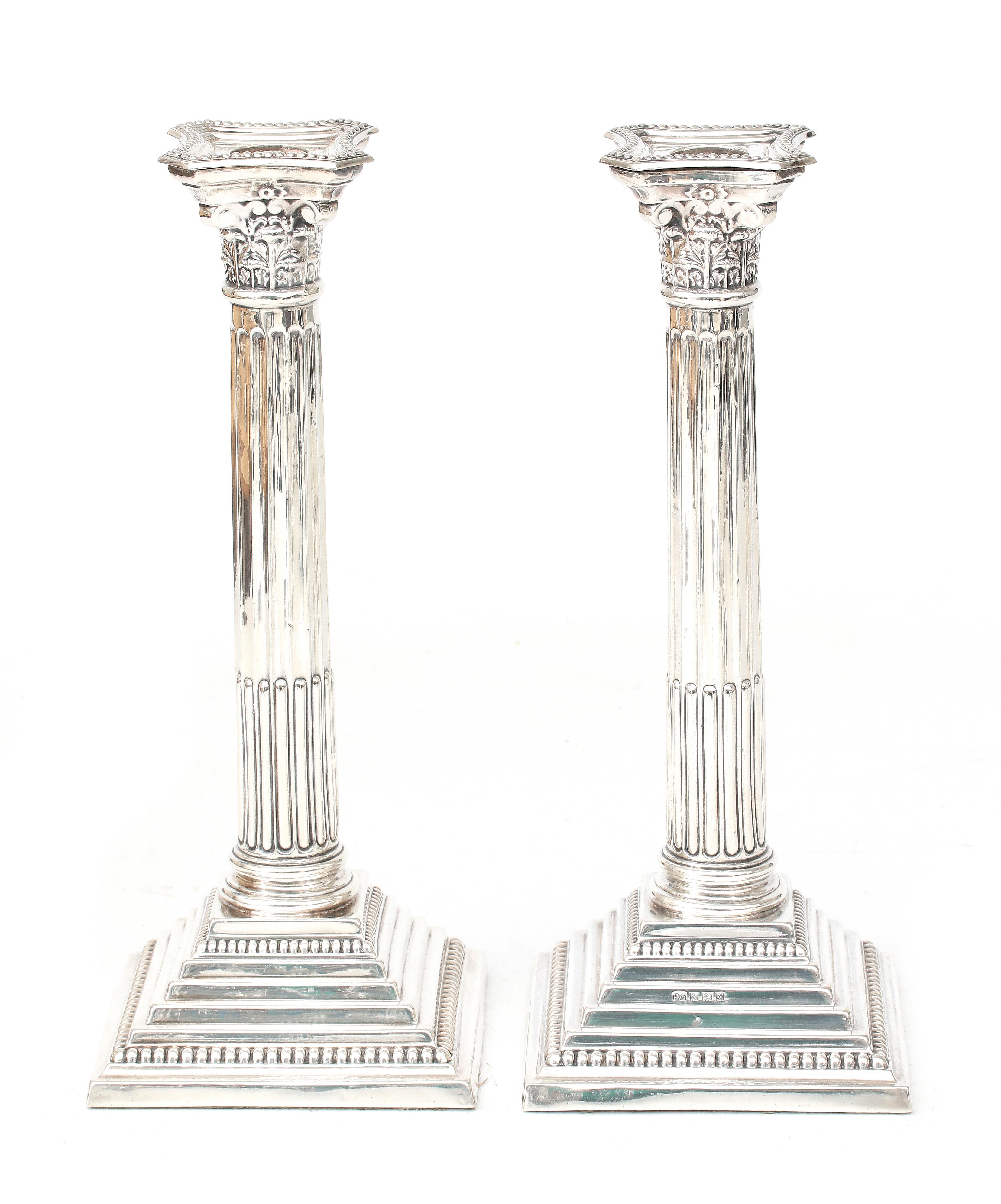 A pair of column shaped silver candle sticks.